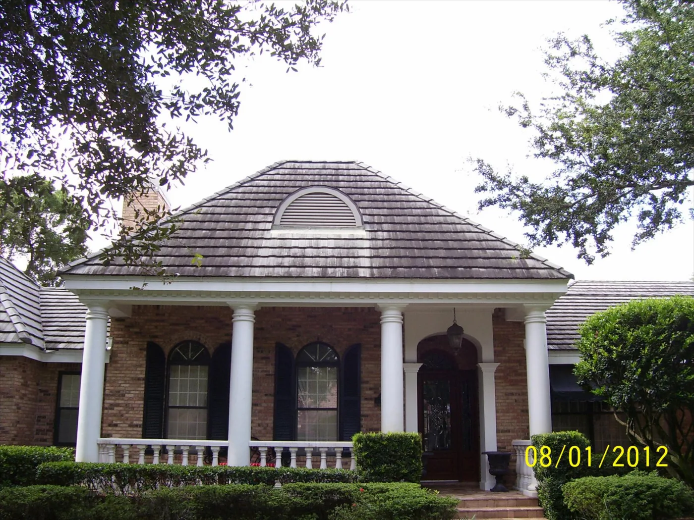 Tile roof over a home entry before cleaning